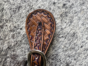 Hand tooled and painted basket weave spur straps.